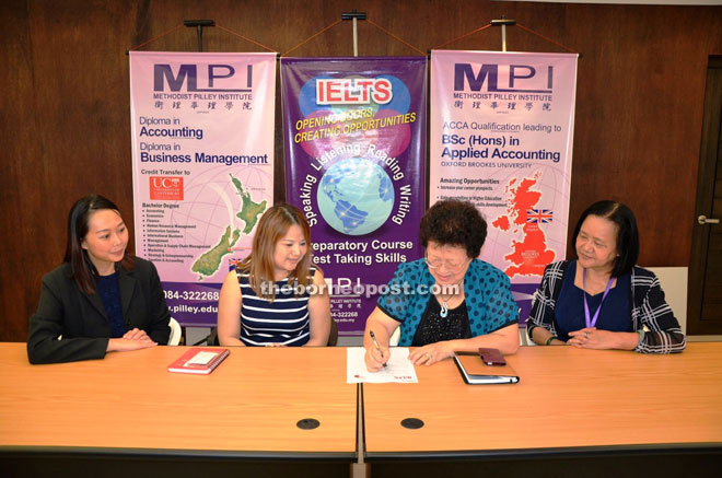 MPI CEO Judy Wong (second right) signs the MoU with IDP Australia, witnessed by (from left) IELTS coordinator Adeline Kho, administrator of IDP Office in Kuching, Alvina Liew and head of Lifelong Learning Department of MPI, Fidelia Hii.