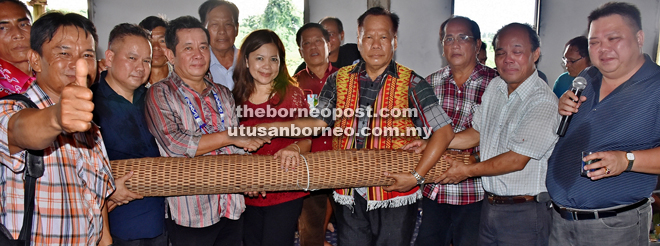 Alexander (third left) handing over a rolled up mat to Adrian to end the Gawai celebration at Rumah Adrian Luang, Bukit Temedak, Sungai Bawan in Kanowit. At fourth left is Susan.