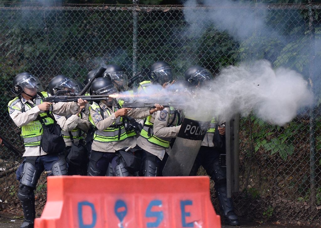 Riot police fire rubber bullets and tear gas grenades at students from the public Central University of Venezuela who demonstrate in demand of the referendum on removing President Nicolas Maduro in Caracas on June 9, 2016. Photo by AFP