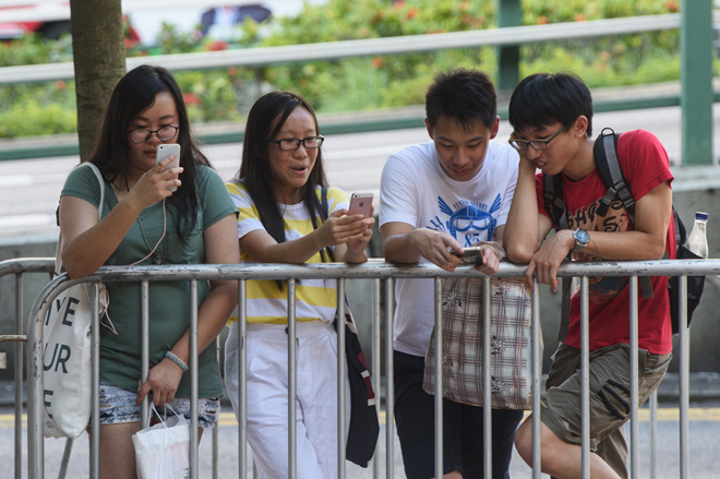 People use their mobile phones to play Nintendo’s Pokemon Go game in Hong Kong. — AFP photo