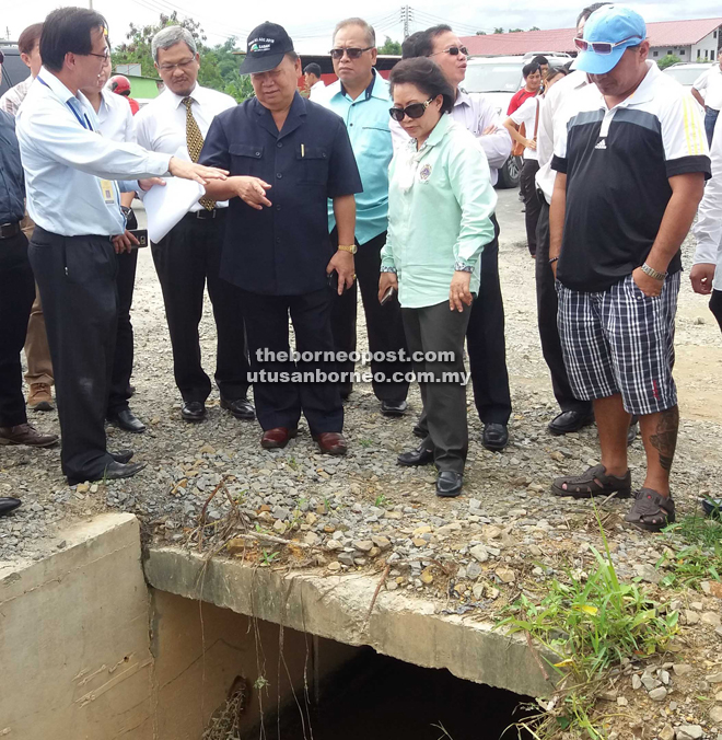 Pairin (third from left) and Luvita (fifth from left) listening to the explanation given by the engineer present on the flood issue at Kampung Nambazan.