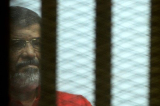 Egypt's ousted Islamist president Mohamed Morsi, wearing a red uniform, looks on from behind the defendant's bars at a court in Cairo on June 18, 2016 -AFP photo