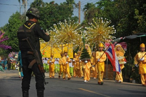 A Thai soldier watches as Muslim schoolchildren participate in the opening parade of the Kadrika Sampan festival in the Rangae district of Thailand's restive southern province of Narathiwat on April 16, 2016 -AFP photo