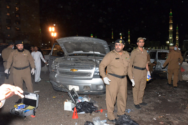 Saudi security personnel gather at the site of the suicide attack near the security headquarters of the Prophet’s Mosque in Medina City. Four Saudi security personnel were killed and five others wounded in a suicide bombing outside the Prophet’s Mosque on Monday. — AFP photo