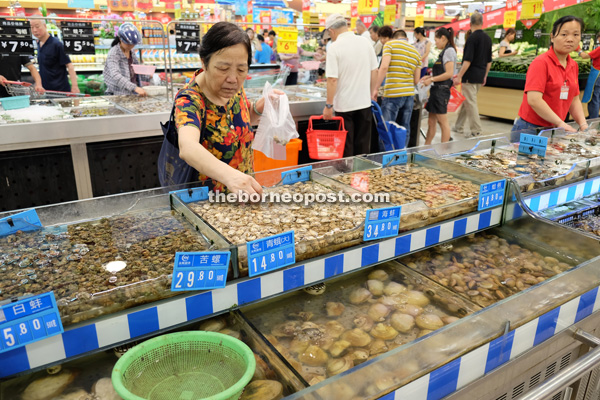 A woman is seen picking shells at Yong Hui General Merchandise Supermarket.