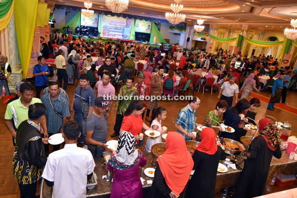 Guests help themselves to the food during the Hari Raya open house hosted by Nancy at the old DUN Complex.