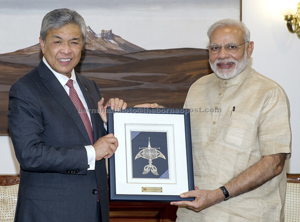 Ahmad Zahid (left) presenting a memento to Modi during a meeting in New Delhi yesterday. — Bernama photo