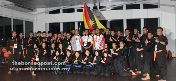 BUAT YANG TERBAIK: Abdul Karim (tengah) diapit Fazzrudin (kanan) dan Yusnar bergambar bersama jurulatih, pegawai dan pesilat pada majlis berkenaan.