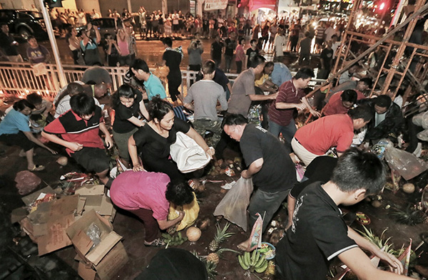 Worshippers scurry to collect food items after the priests offer prayers and sprinkle flour to symbolically feed the hungry ghosts.
