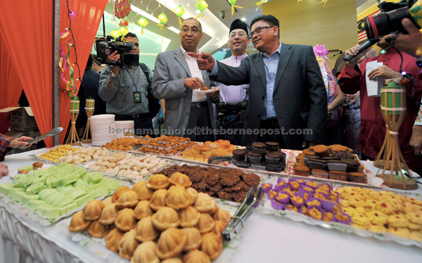 Salleh (second left) trying some of the biscuits at the Bernama Aidifitri Open House at the Communications and Multimedia Ministry in Putrajaya.— Bernama photo