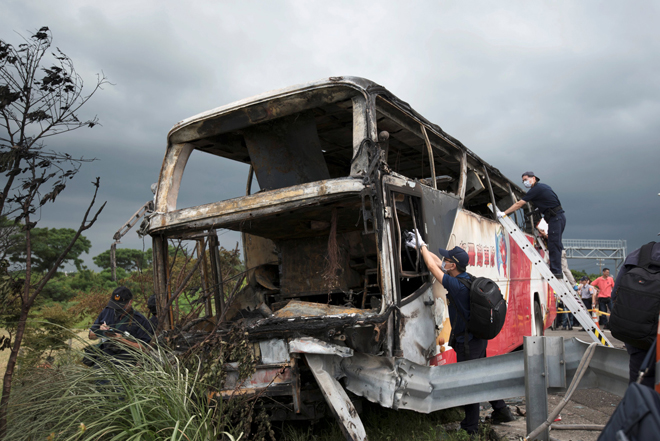 Police and other emergency personnel work around the wreckage of a bus that crashed en route to Taoyuan airport, just south of the capital Taipei. — Reuters photo