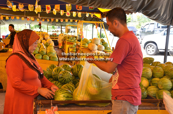 Hamdan helping to pack watermelon for his customer.