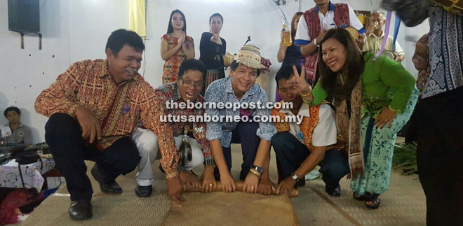 Dennis (second left) and the organising committee rolling the mat to mark the end of Gawai Dayak festival.