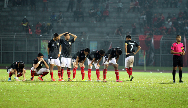 Dismal Sarawak players react after the third penalty miss that sent the team packing in the football quarterfi nals. – Photo by Chimon Upon