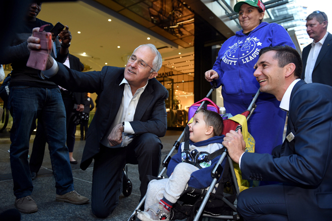 Turnbull (left) and member-elect for the Federal seat of Brisbane Trevor Evans (right), pose for a selfie with a woman and child in Brisbane, Australia. — Reuters photo