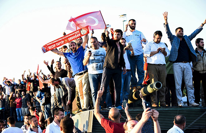 People stand and celebrate on an army tank after taking over military position on the Bosphorus bridge in Istanbul, Turkey following an attempt by discontented soldiers to seize power from President Recep Tayyip Erdogan that claimed more than 250 lives. — AFP photo