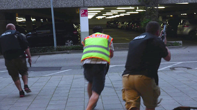 A screen grab taken from video footage shows plainclothes police officers running towards the car park of the Olympia shopping mall during the shooting rampage in Munich. — Reuters photo