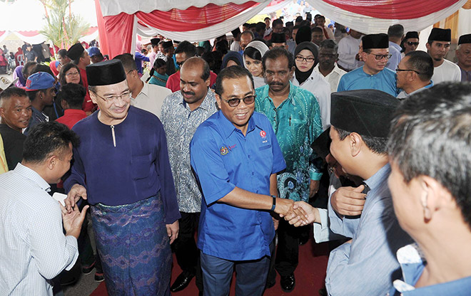 Hishammuddin (left) and Khaled greeted upon arrival for the Sembrong parliamentary constituency Aidilfitri event at Dewan Kejora. — Bernama photo