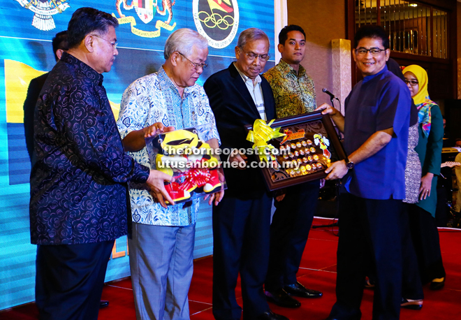 Adenan (third from left) presenting a souvenir to an official as (from left) Morshidi, Manyin and Khairy look on.