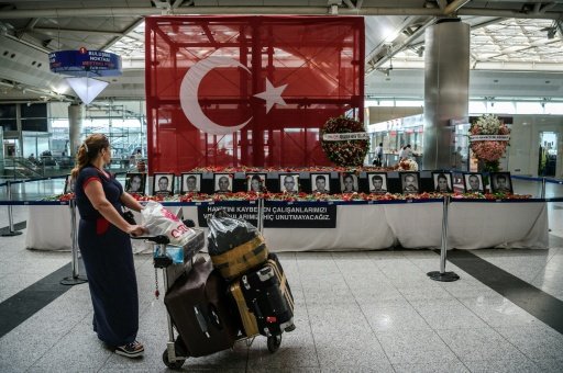 A passenger looks at the pictures of airport employees killed in the attack at Ataturk airport international terminal in Istanbul. Photo by AFP