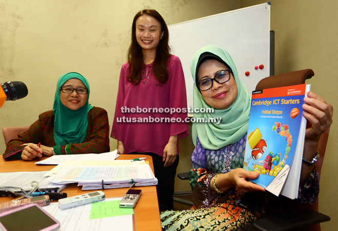 Fatimah showing the CIS course book. With her is Tan and the ministry’s special administration officer Dr Siti Zaliha Reduan. — Photo by Muhd Rais Sanusi 