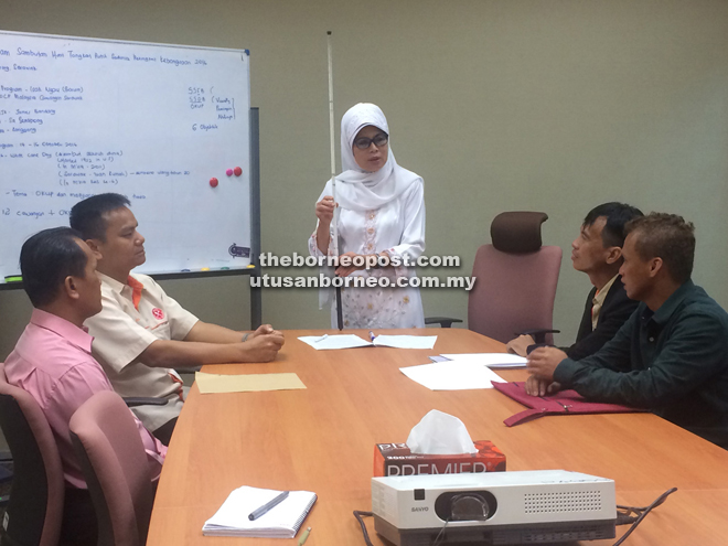 Fatimah handling the white cane belonging to Sa while she discusses the upcoming national-level White Cane Day 2016 which Kuching will be hosting.