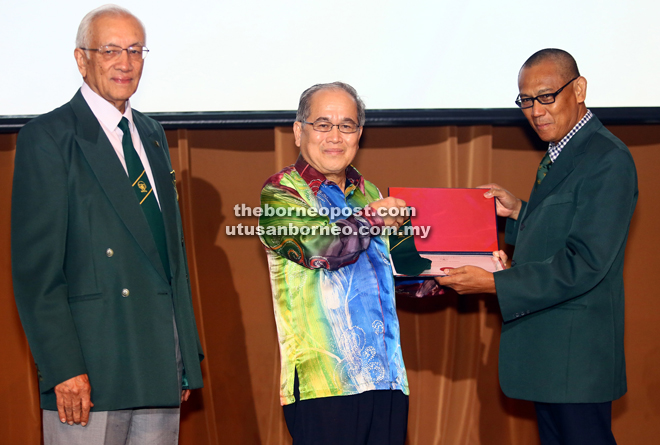 Uggah (centre) receiving his Fellowship of Incorporated Society of Planters Award from Daud. 