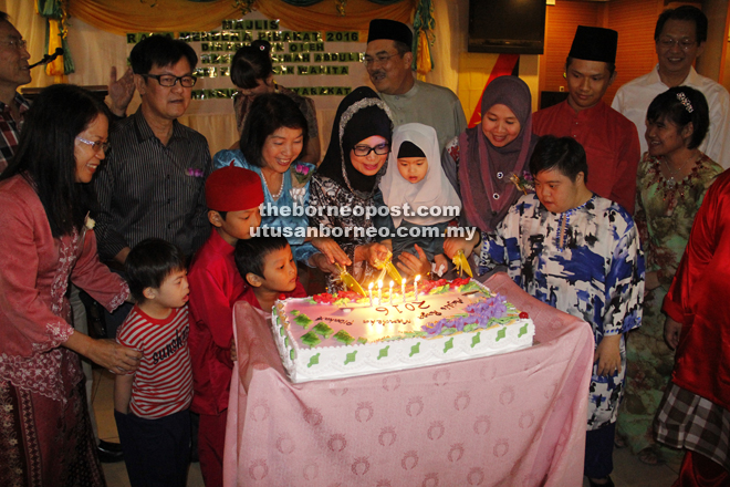Fatimah (fourth from left), with Ng on her right, leads the cake-cutting ceremony. Behind the minister is Zaidi. 