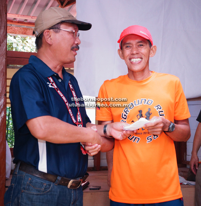 Gabriel (left) presents the prize for the winning of the Jagoithon Men’s Veteran category.