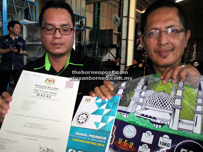 Abdul Hafidz (right) showing the rice packaging with halal logo that is not recognised by Jais and Jakim and the procedure manual to obtain halal certification from Jakim. On the left is Jais Halal Management Division principal assistant director Khalipah Juli, who is holding the halal certification obtained by K.E.K. Trading (Kuching) Co Sdn Bhd early this year. — Photo by Jeffery Mostapa