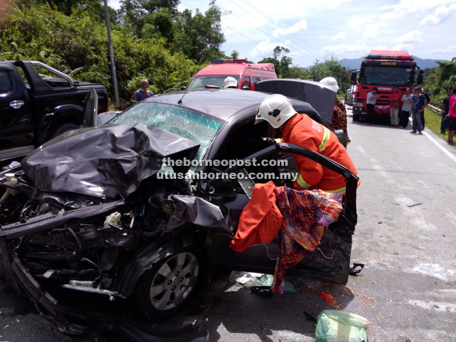 Bomba personnel trying to free Ratnawati from the wrecked Saga.