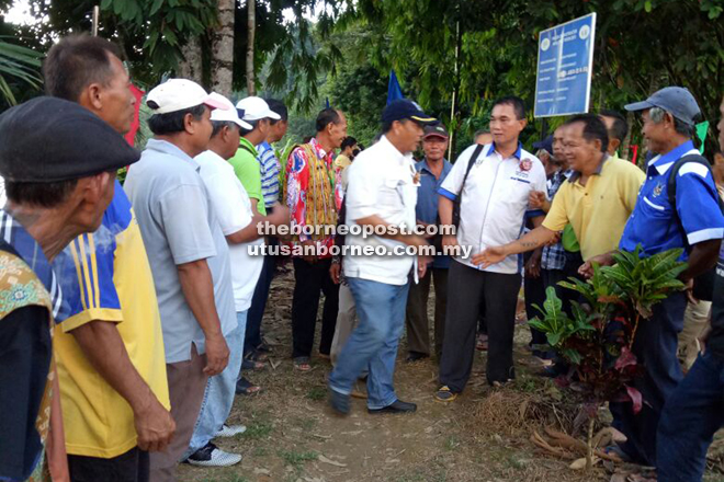 Villagers line up to greet Ugak (centre) upon his arrival at Rumah Untam. 