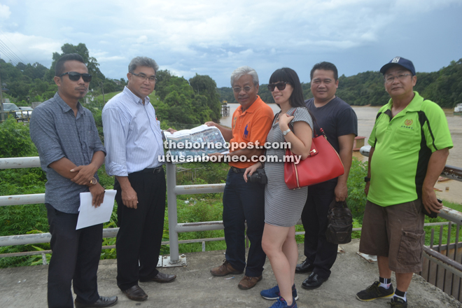 Masing and Watson (third and second left, respectively) show the proposed plan for the jungle produce market.