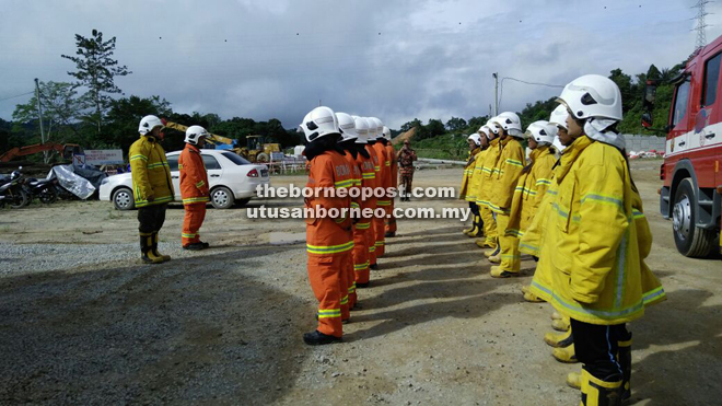 Lining up in full gear to attend the briefing on the fire drill.