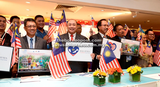 Hajiji (front row, third left) and other guests showing the Jalur Gemilang after the press conference yesterday. 