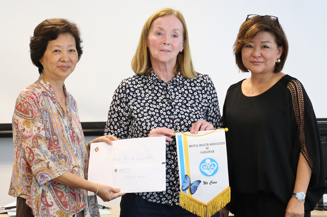 Dr Ling (left) and Dr Adeline Wong (right) from MHA Miri present a token of appreciation to Dr Martin.