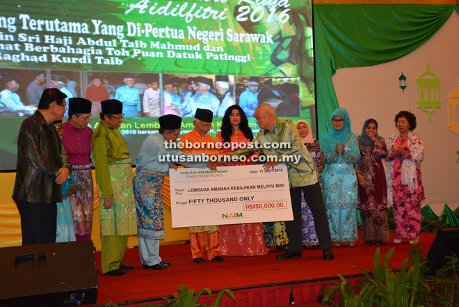Taib (seventh right) witnesses the handing over of a mock cheque from senior general manager of Naim Group Charles Bateman  (fifth right) to LKAMM chairman Datuk Abdillah Abdul Rahim. 
