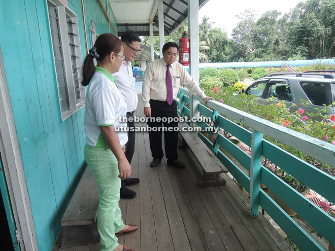Lai (right) and Kuan (left) showing Kong the termite-infected corridor.