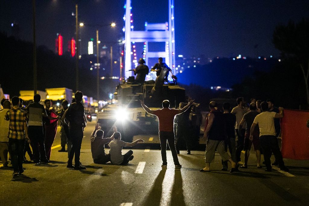 People take over a tank near the Fatih Sultan Mehmet bridge during clashes with military forces in Istanbul on July 16, 2016. Photo by AFP