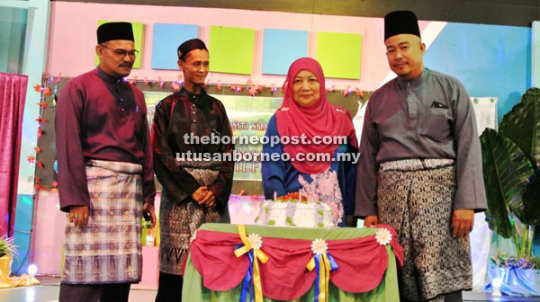 Siti cuts her farewell cake. Also seen from right are SK Dato Sharif Hamid headmaster Badrol Seri, parent-teacher association chairman Ismail Hamid and Education Office representative Wan Omar Wan Hussain.