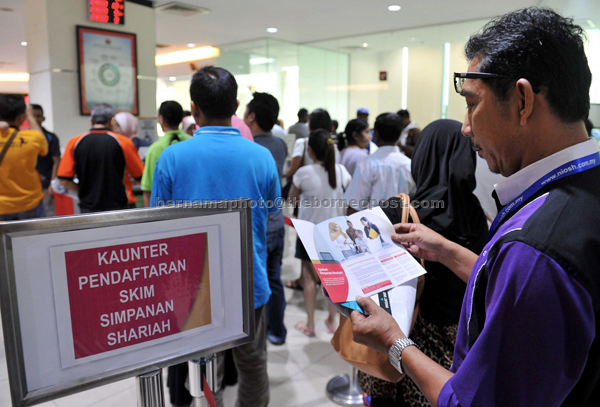 A visitor reading the brochure on Employees Provident Fund’s Simpanan Shariah. — Bernama photo