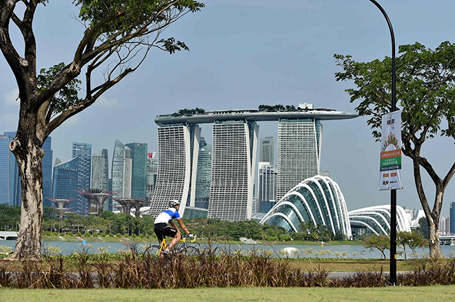 This file photo taken on April 8, 2016 shows a man as he cycles along a park next to Marina Barrage overlooking the skyscrapers of Singapore. — AFP photo