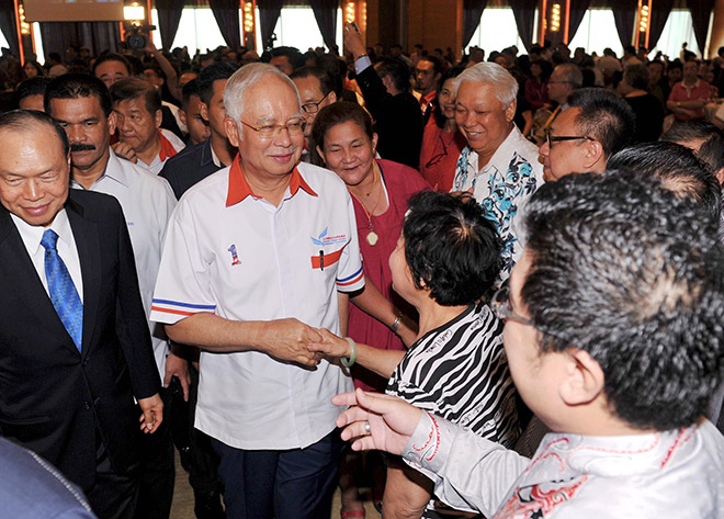 Najib (centre) greeted upon arrival for the MCWEF function. — Bernama photo