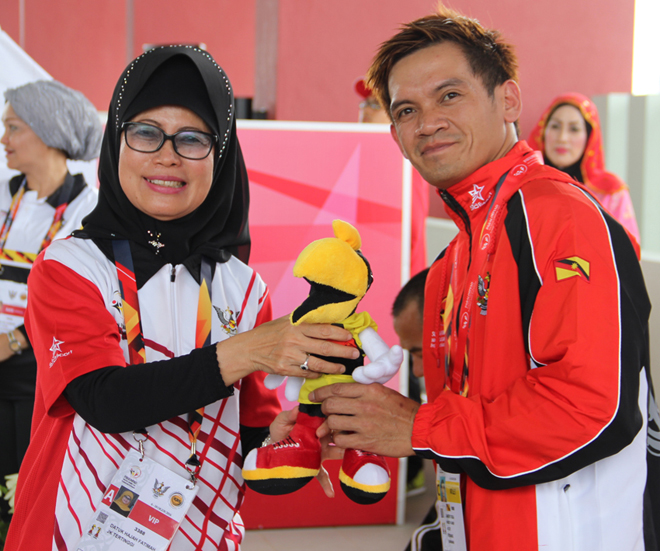 Jemary receives his medal and prizes from Welfare, Women and Community Wellbeing Minister, Datuk Fatimah Abdullah.