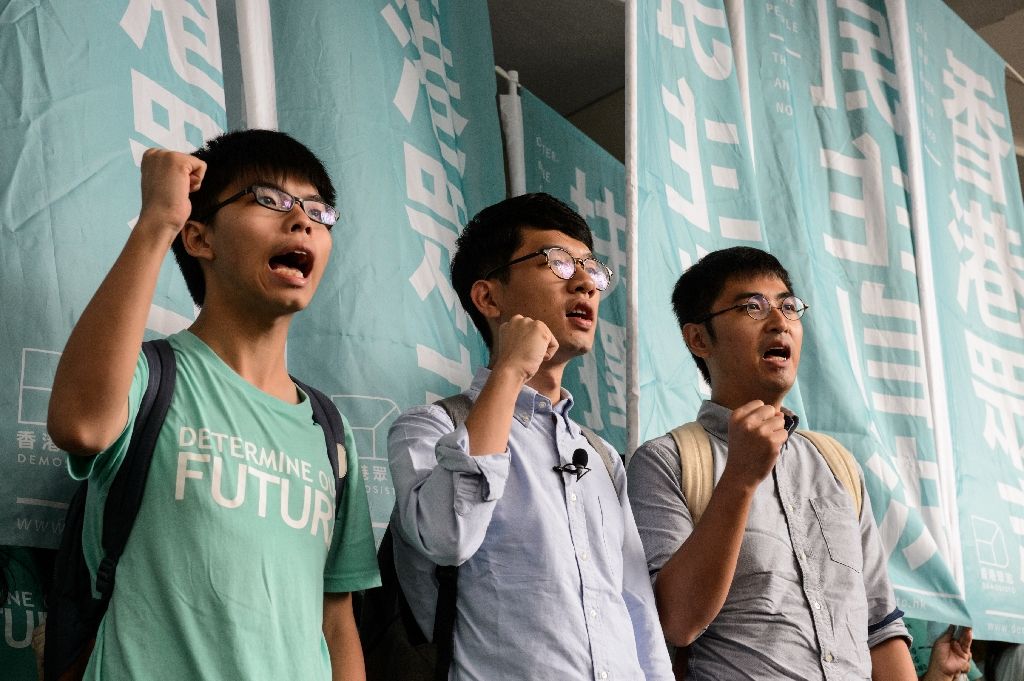 Leaders of Hong Kong's 'Umbrella Revolution' (from left) Joshua Wong, Nathan Law and Alex Chow chant slogans upon their arrival to the Eastern Court, on Aug 15, 2016. Photo by AFP