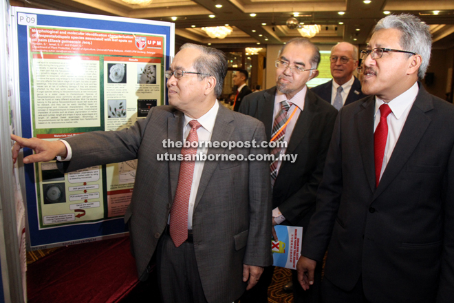 Uggah goes through some of the exhibits on display during the 9th ICPPT as Hafidzi (centre) and Abdul Shukor (right) look on. — Photo by Chimon Upon