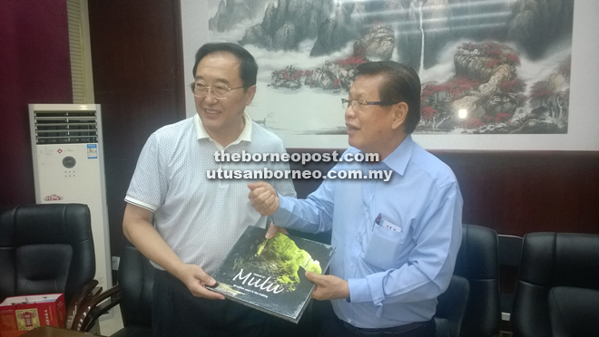 Lee (left) presenting a memento to Gao after their meeting at the Heibei Tourism office. 