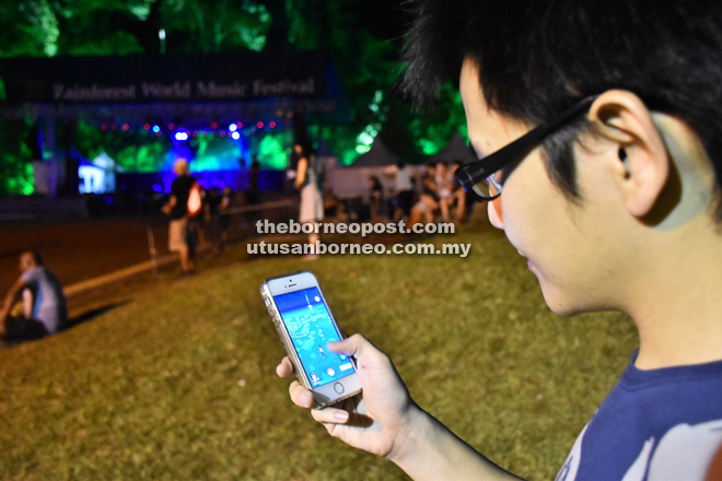 A reveller at Rainforest World Music Festival on Sunday night is seen playing Pokemon Go.