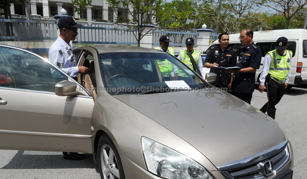 Police personnel checking the car driven by the drug trafficking suspect. — Bernama photo 