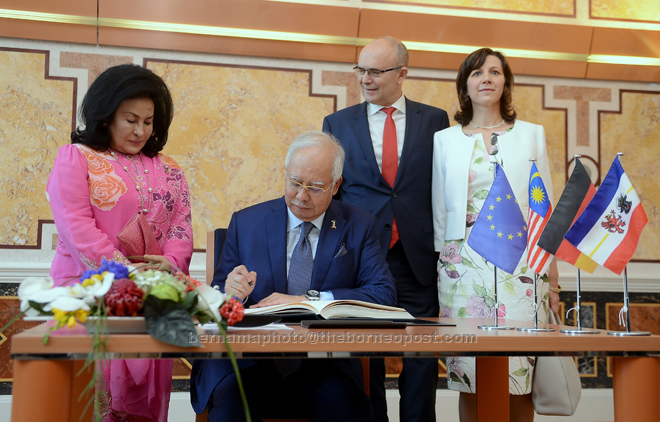 Najib signing a golden book upon arrival at the State Chancellery of Mecklenburg-Vorpommem yesterday, the third day of his official visit to the Federal Republic of Germany — while Rosmah (left) and president of the Federal State of Macklenburg-Vorpommem, Erwin Sellering (second, right) and wife Britta Sellering look on. — Bernama photo 